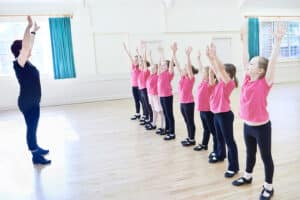 A group of young girls in pink shirts and jeans.