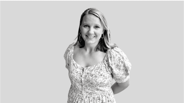 Woman in floral dress smiling at camera.