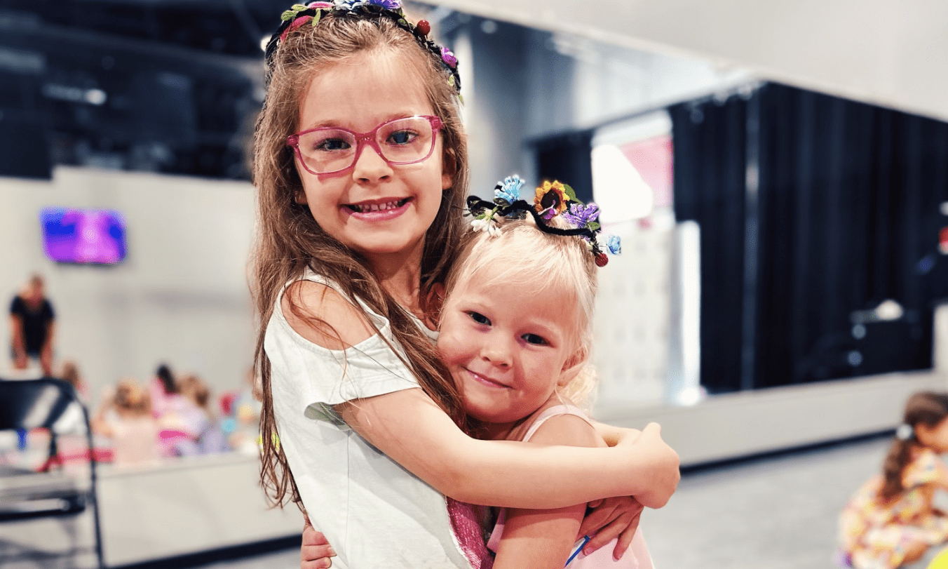 Two girls hugging, smiling, flower crowns.